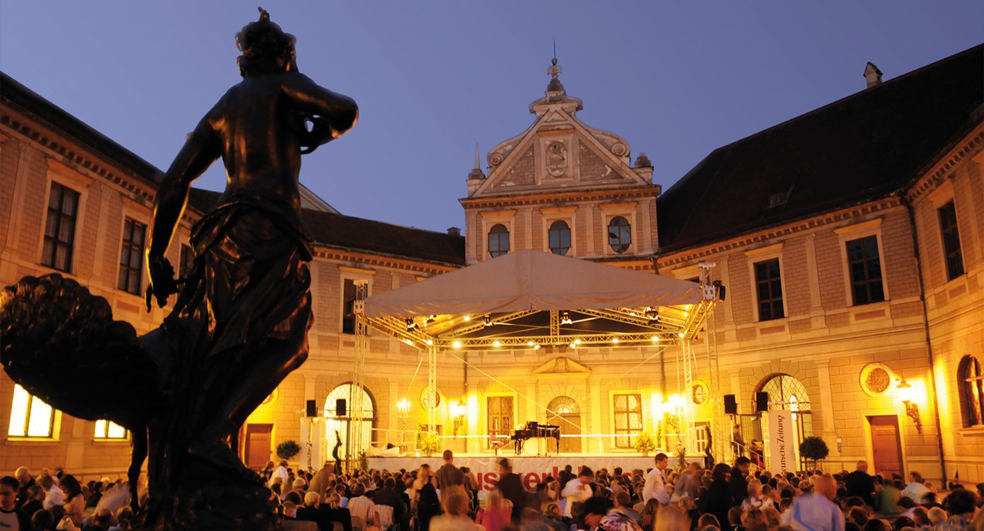 ein Brunnen, eine Bühne und das Publikum