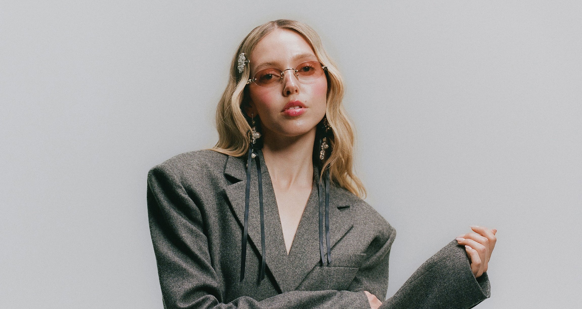 Blonde Dame  mit Sonnenbrille in grauem Sakko