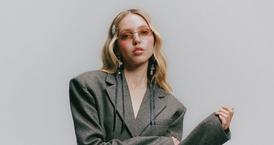 Blonde Dame  mit Sonnenbrille in grauem Sakko