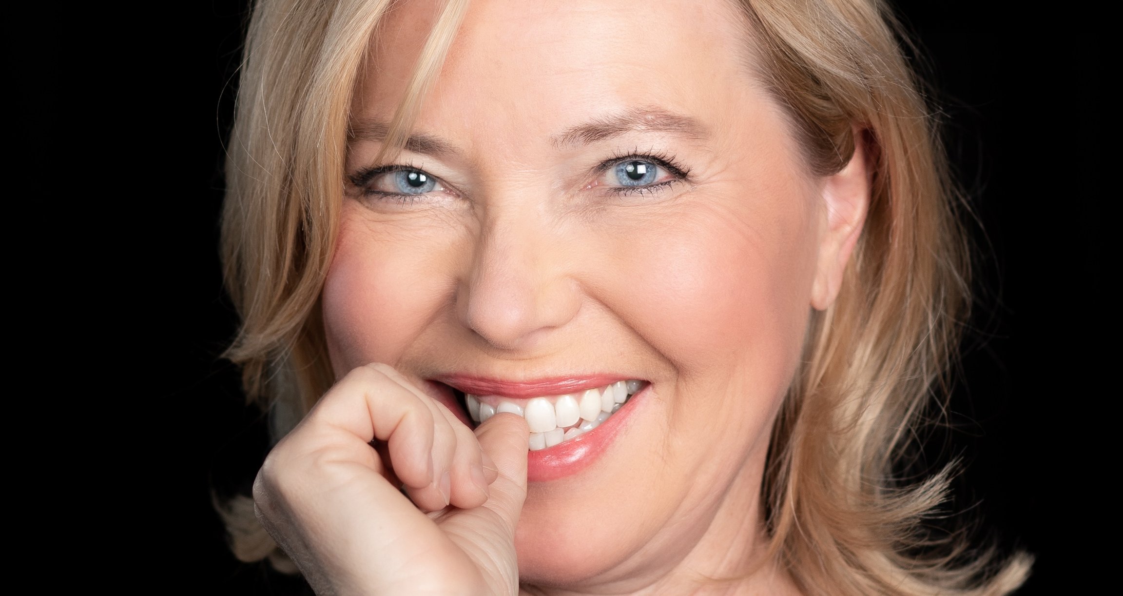 Portrait von blonder Dame mit schwarzem Hintergrund