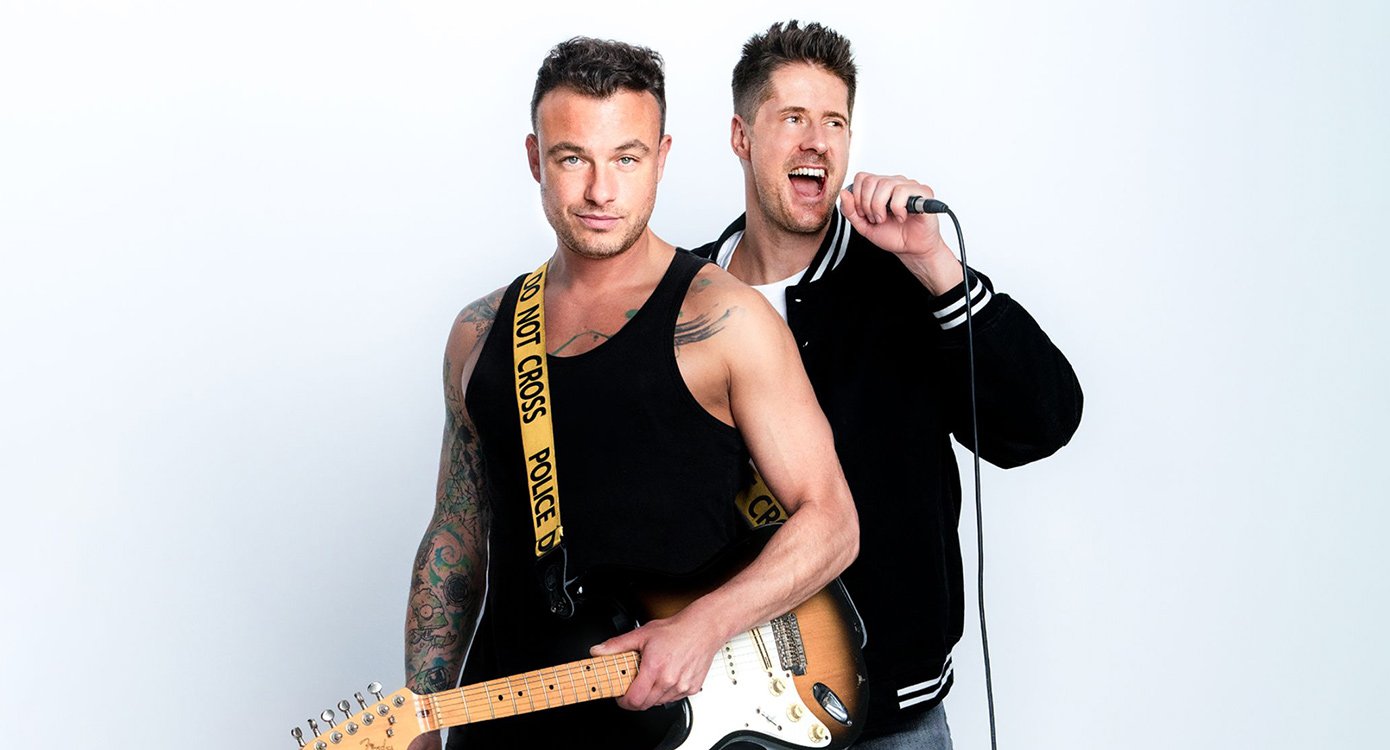 Zwei Musiker, einer mit Mikrofon, einer mit Gitarre vor hellem Hintergrund