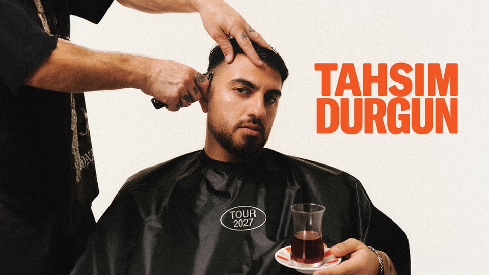 Plakat von Tahsim Durgun beim Haareschneiden, sitzend mit Friseurumhang und Teeglas in der Hand, daneben der Schriftzug Tahsim Durgun und Tour 2027
