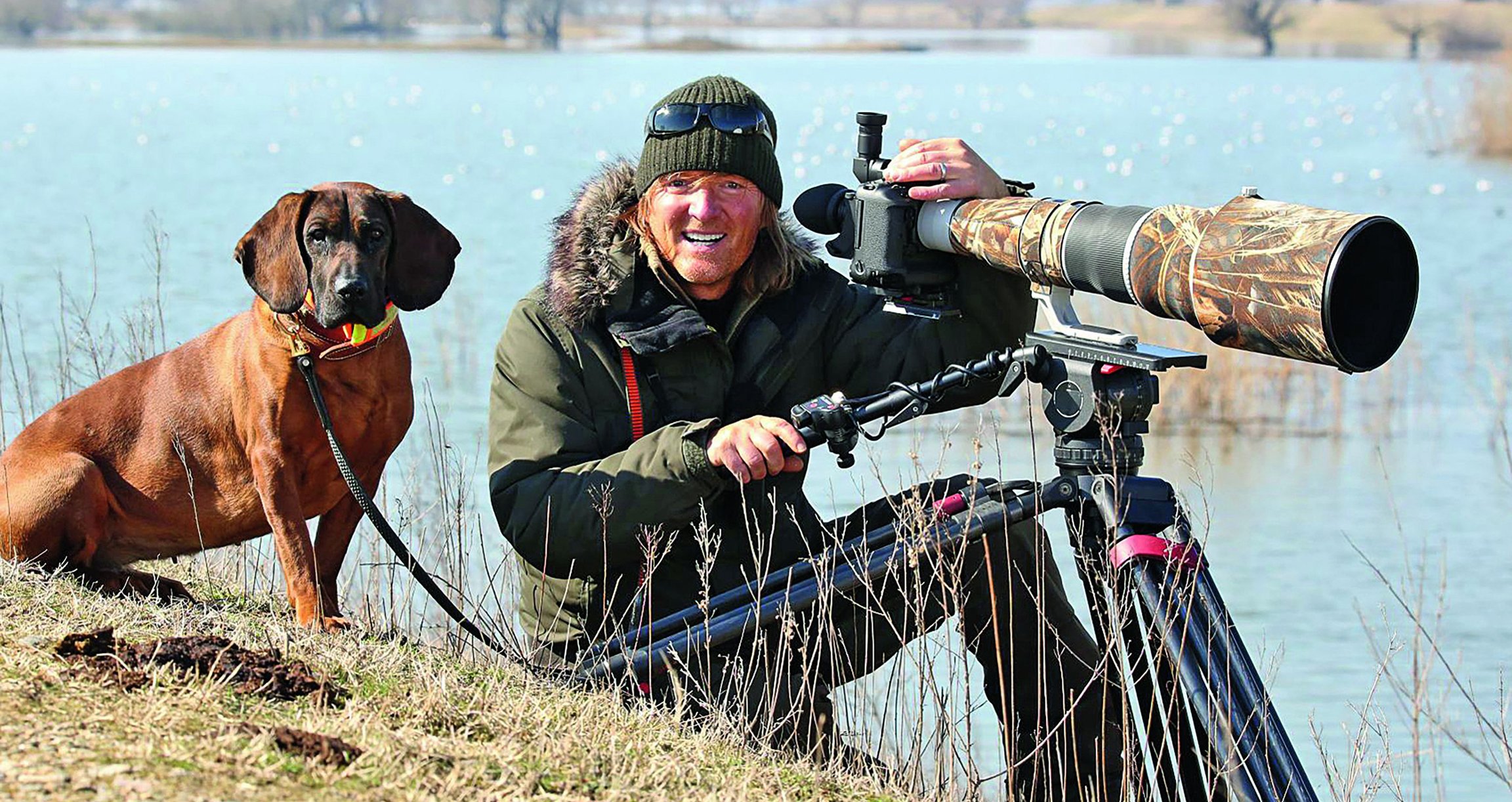 Andreas Kieling mit Hund und Fernglas in der Natur