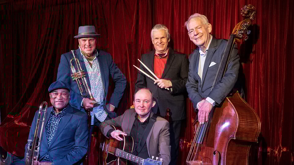 Foto der Band The Hot Stuff Jazzband, auf der die Mitglieder mit ihren Instrumenten zu sehen sind.