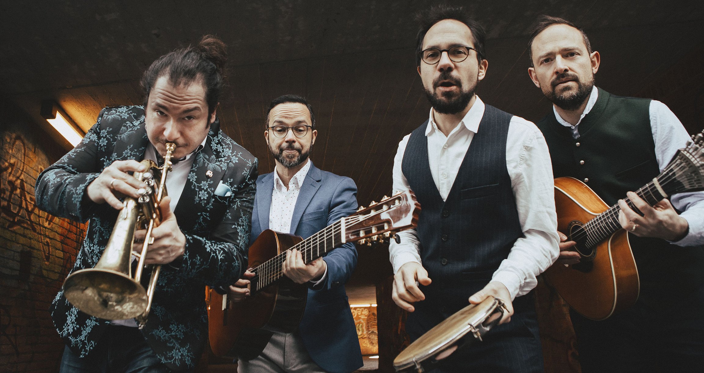 Gruppenfoto mit vier Männern mit Instrumenten