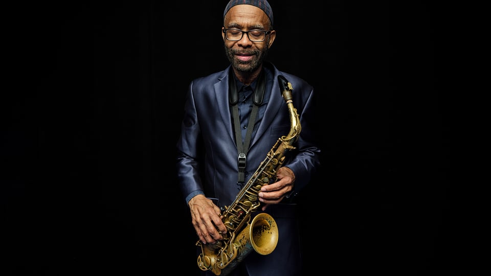 Foto für das Event von Kenny Garrett mit dem Künstler mit einem Saxophon vor schwarzem Hintergrund.