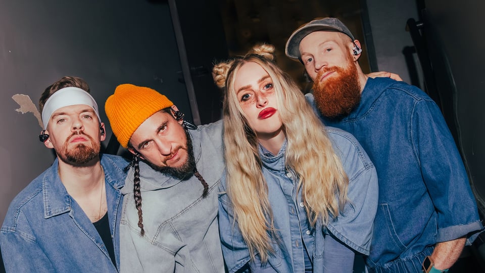  Bandfoto Walk Off The Earth, vierköpfige Gruppe im Close-up mit modernem Indie‑Pop‑Look