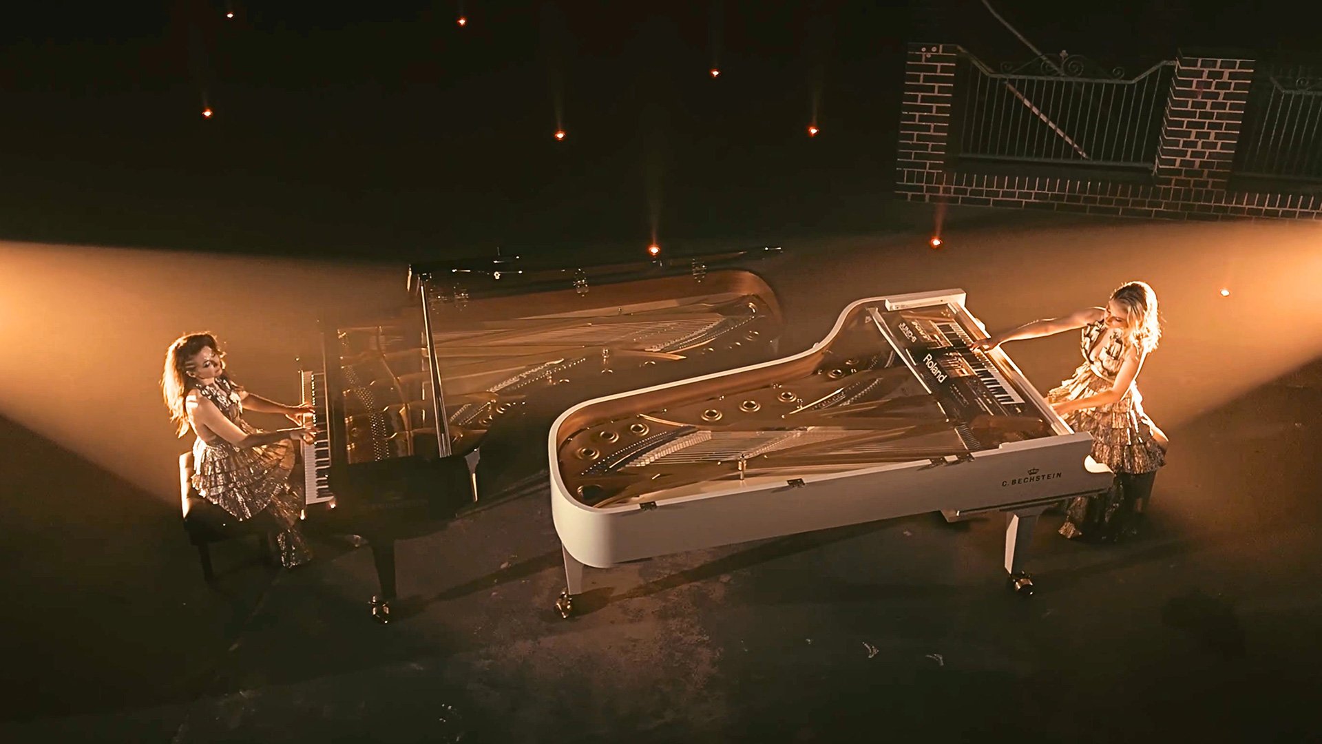 Foto für das Event QUEENZ OF PIANO – Piano Cosmos Tour 2027 mit einer Aufnahme aus der Vogelperspektive, auf der beide Künstlerinnen jeweils an einem Klavier sitzen