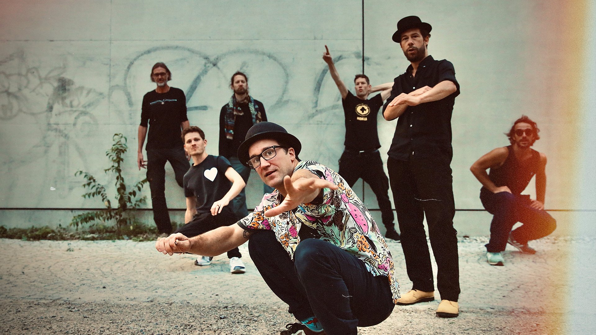 Die band vor einer Mauer mit Graffiti