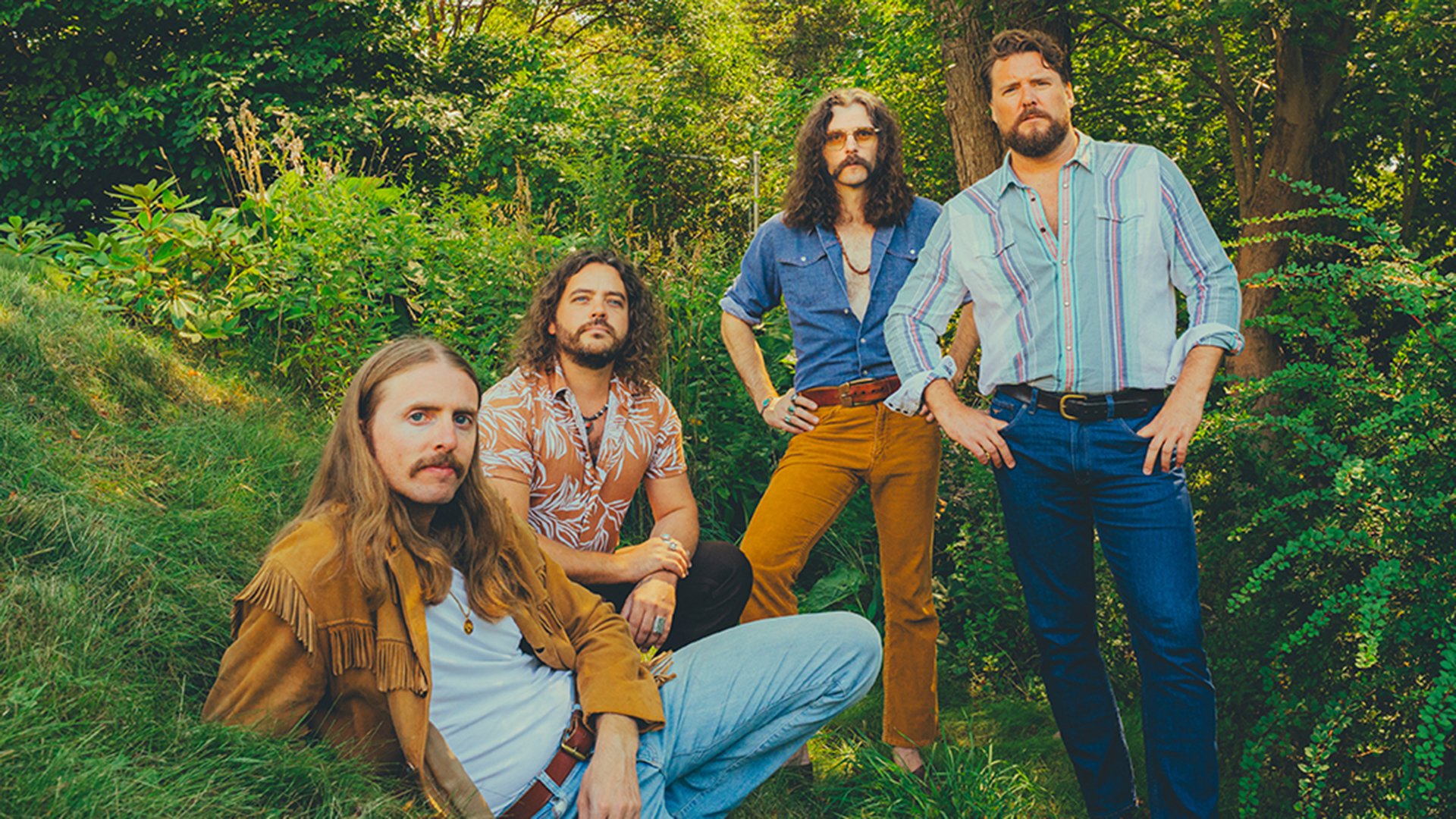 Vier Musiker der Band in einem Wald