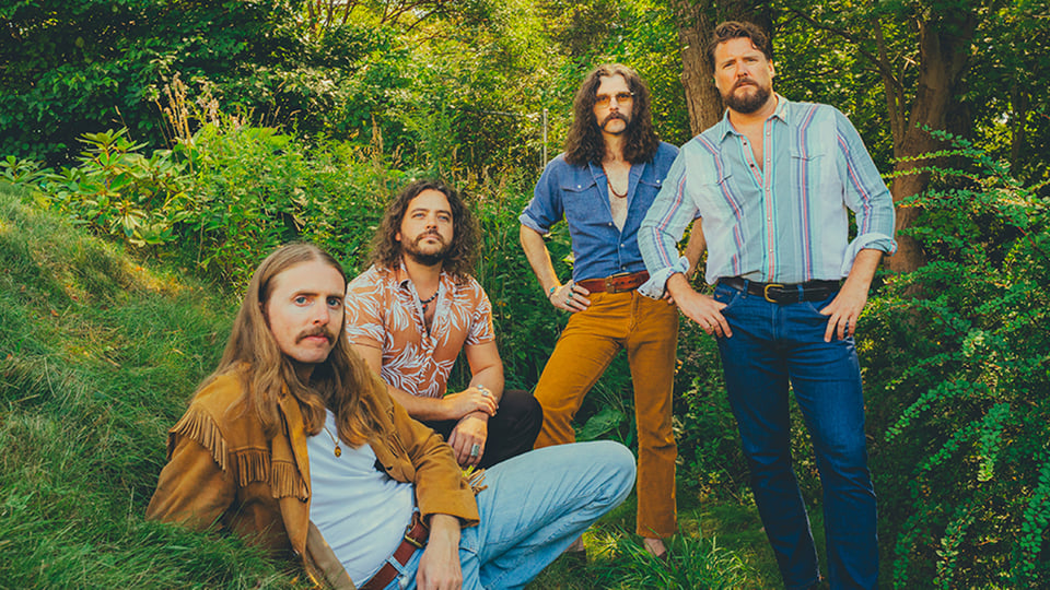 Vier Musiker der Band in einem Wald