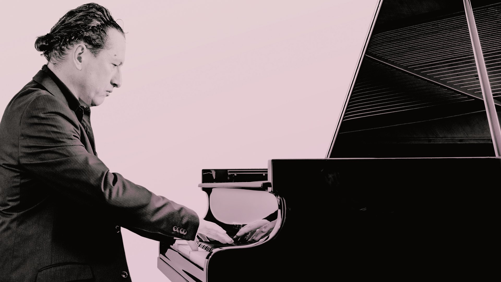 Schwarz-weißes Porträt einer Person am Flügel, sitzt am Klavier und spielt, elegante Konzertaufnahme mit starkem Kontrast und minimalistischem Hintergrund