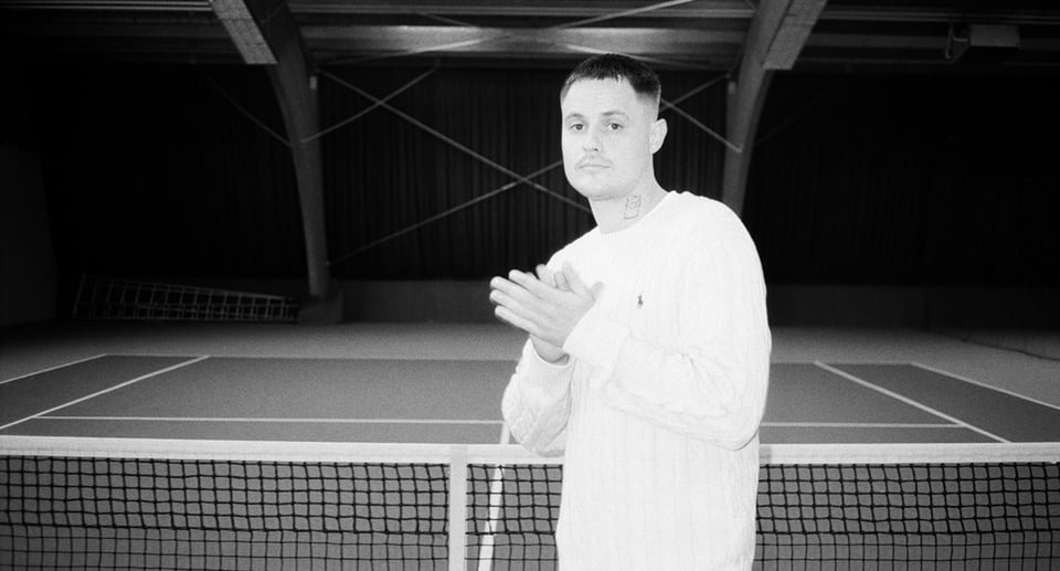 Foto des Künstlers in Schwarz-Weiß auf einem Tennisplatz