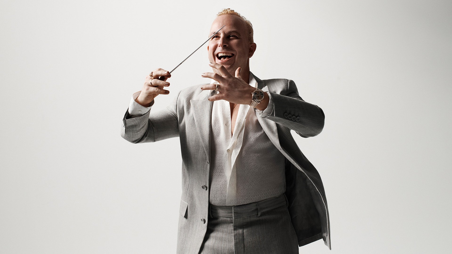 Pressefoto von Yannick Nézet-Séguin, Dirigent mit Taktstock, vor hellem Hintergrund.