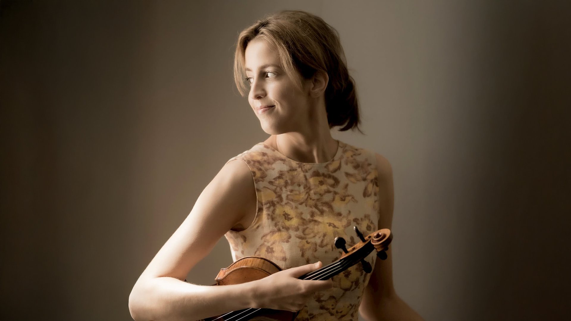 Vilde Frang schaut mit ihrer Violine in der Hand zur Seite.