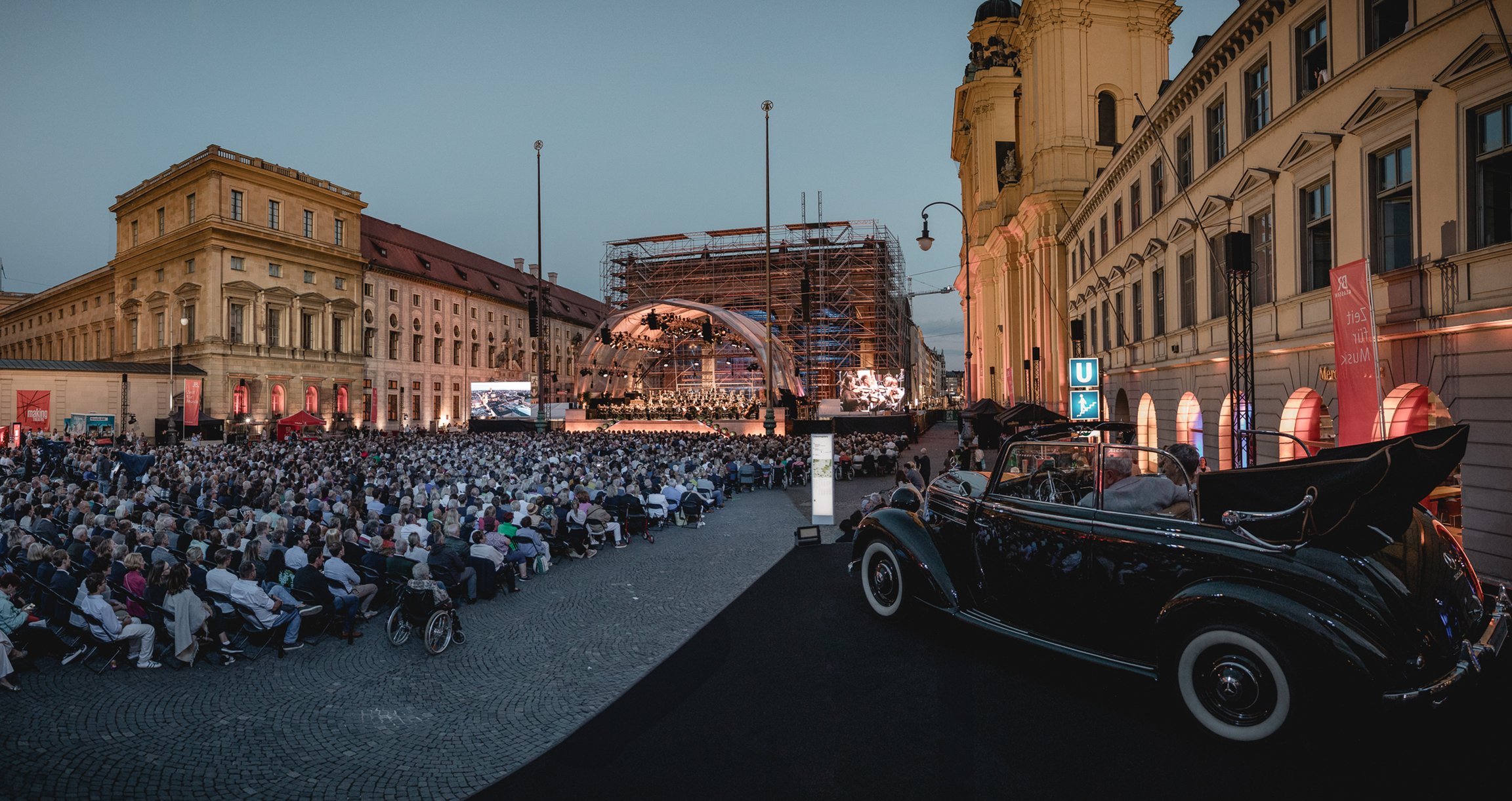 Open Air Konzert mit einem Auto im Vordergrund