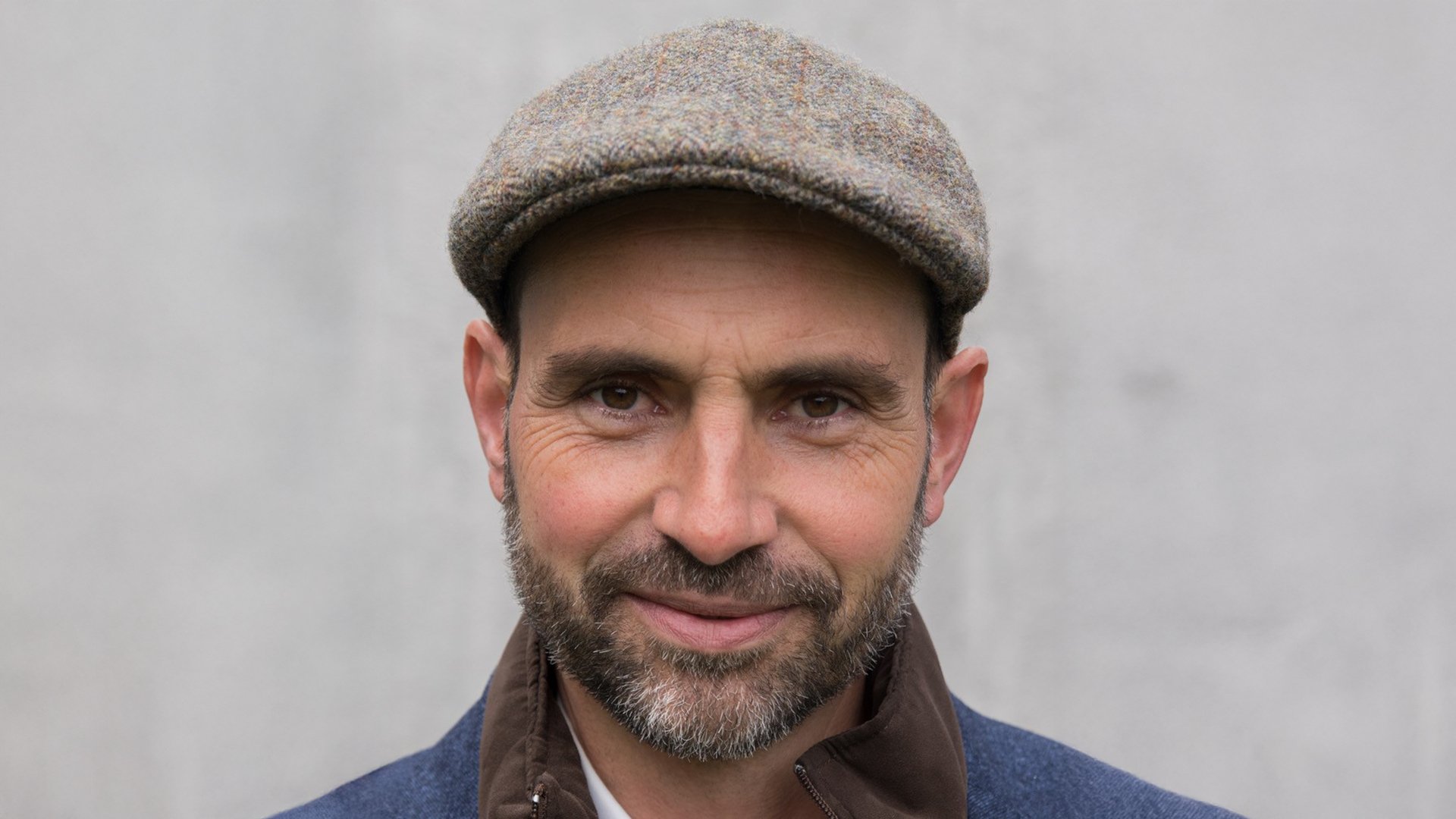 Foto des Künstlers Aurel Bereuter mit einer Baskenmütze vor hellem Hintergrund