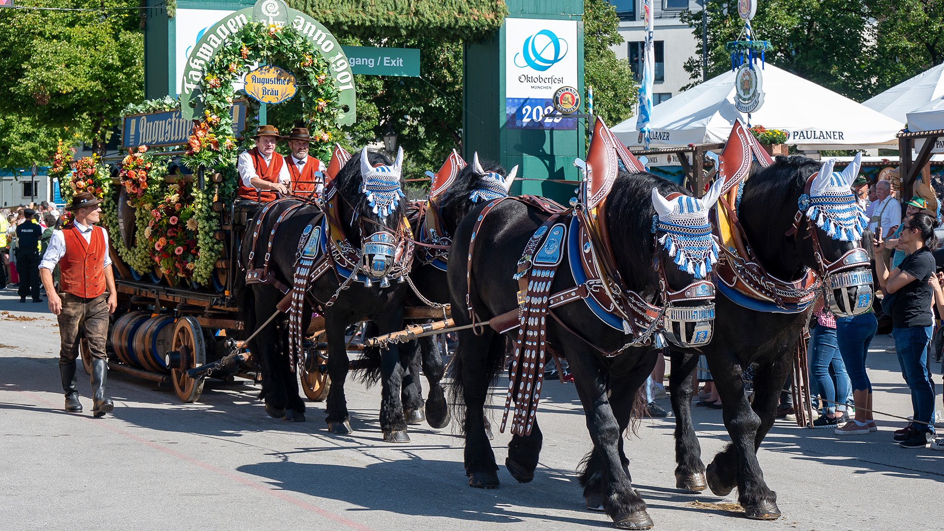 Ein Festzug mit Pferden und einem geschückten Wagen