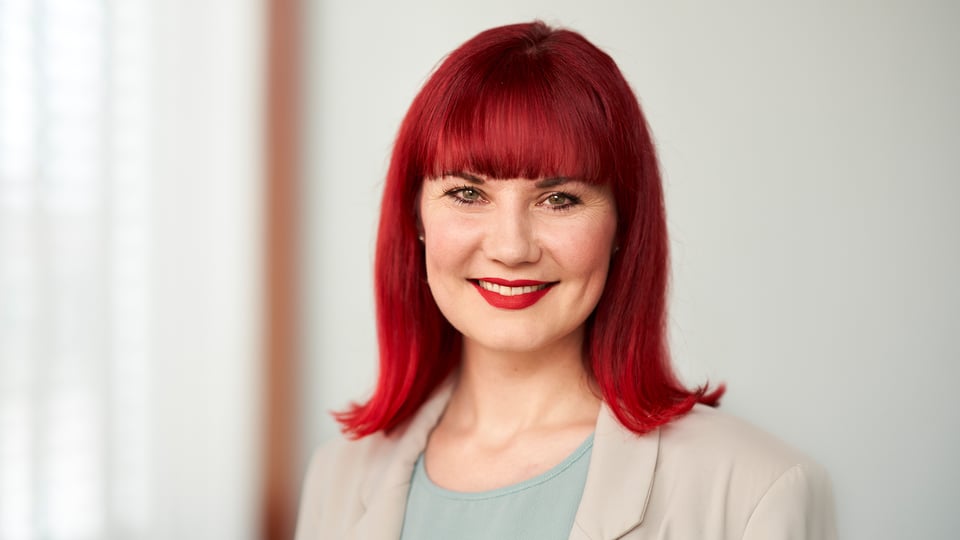 Portzrait von Sarah Traub mit roten Haaren vor hellem Hintergrund
