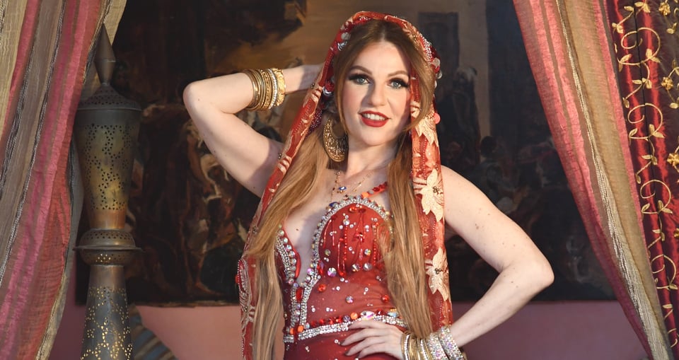 Tänzerin in orientalischen Klamotten vor rotem Hintergrund