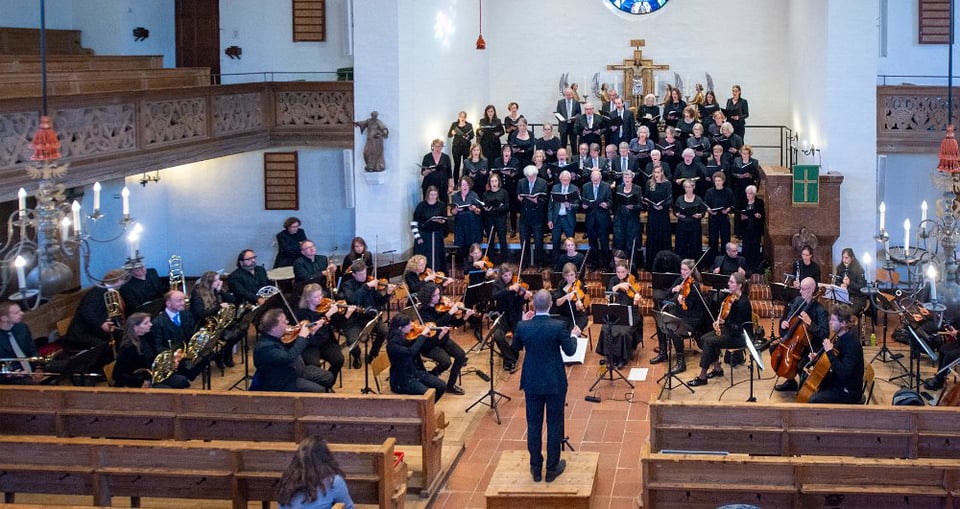 Orchester mit Instrumenten in der Hand in einer Kirche
