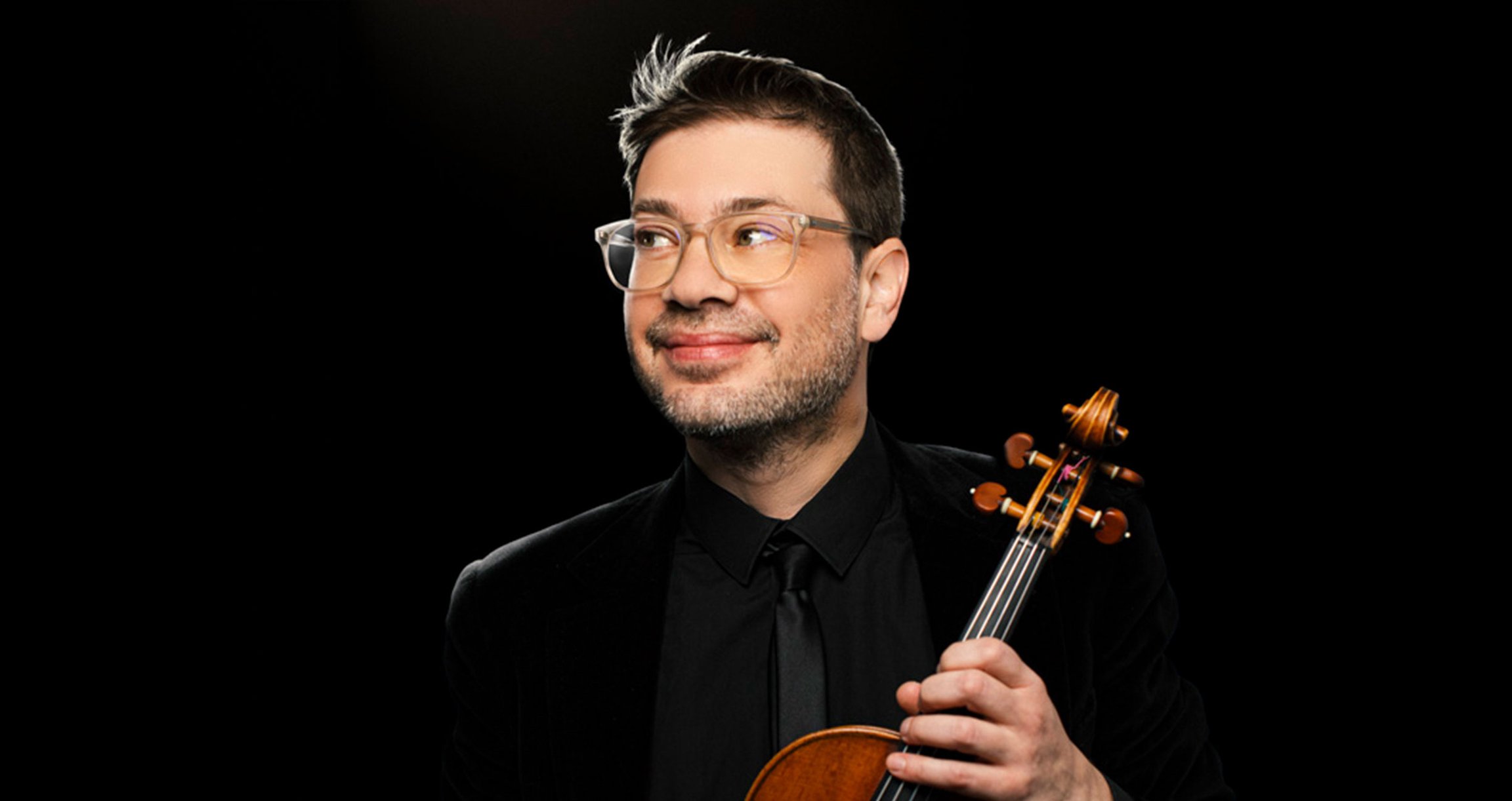 Mann mit Instrument vor schwarzen Hintergrund