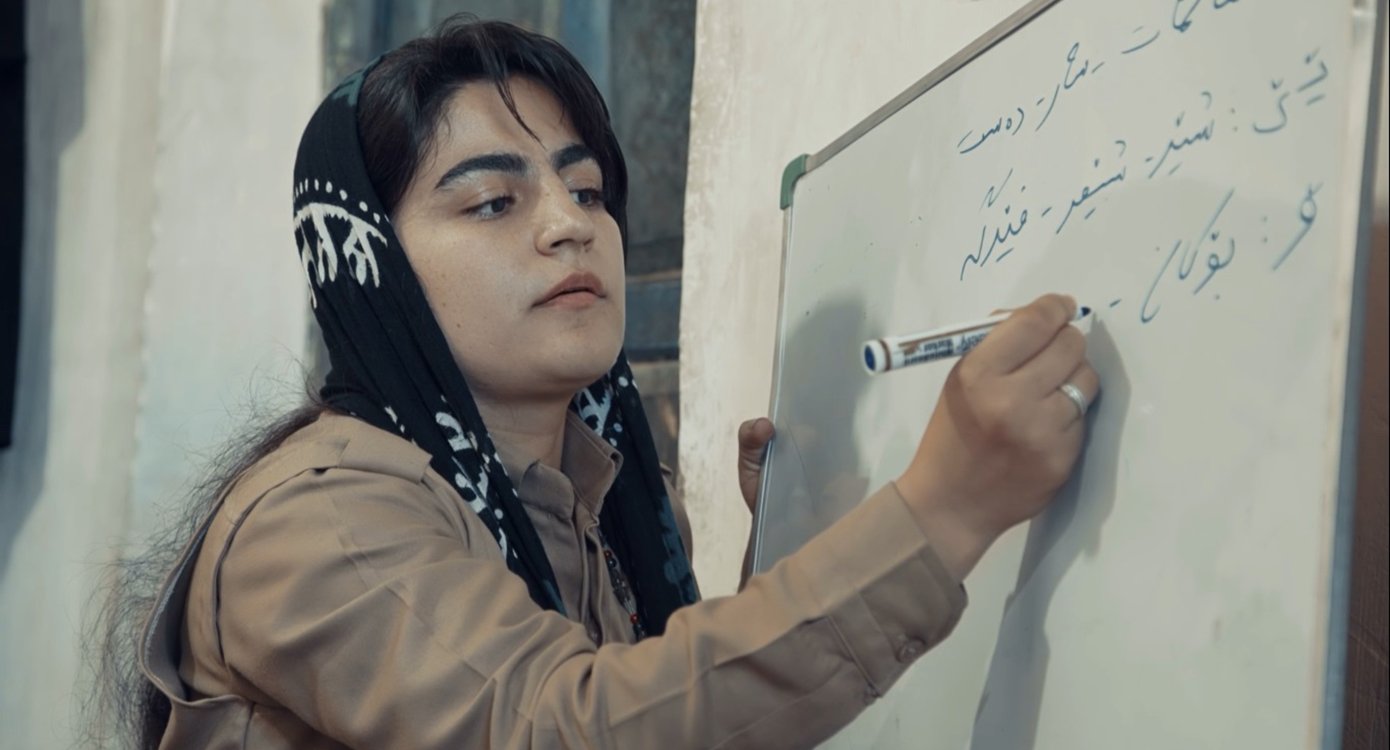 Mädchen schreibt in arabischer Sprache auf eine Tafel