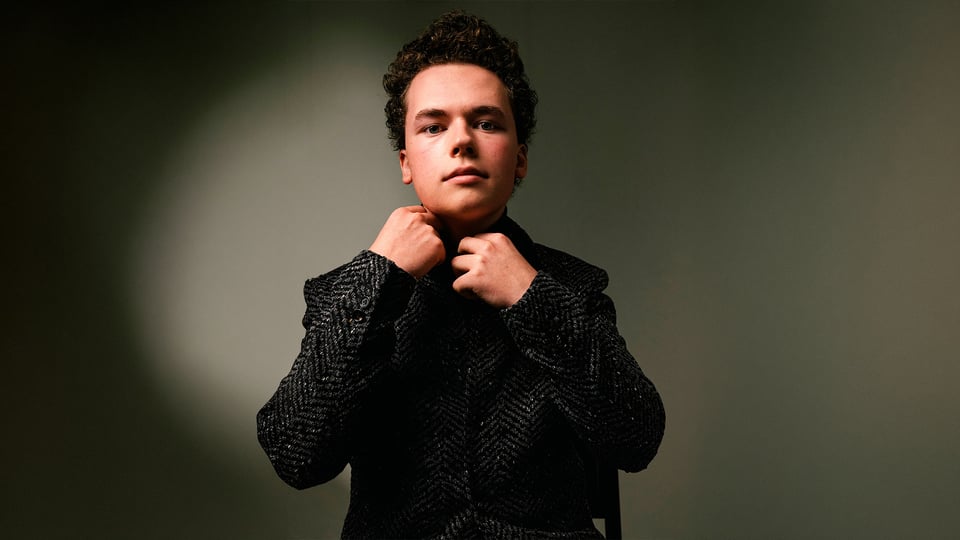 Der Pianist Vsevolod Zavidov in einer dunklen melierten Jacke vor grau-grünem Hintergrund