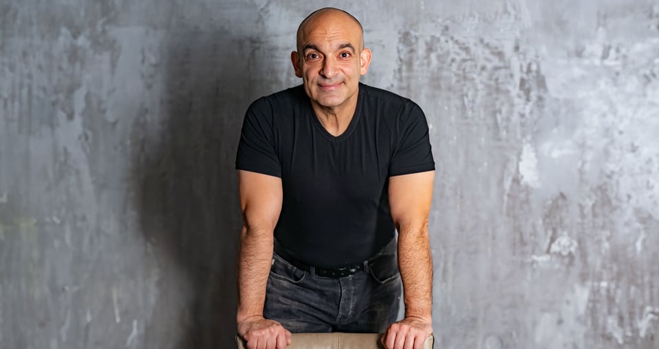 Mann in dunklem Shirt vor hellem Hintergrund