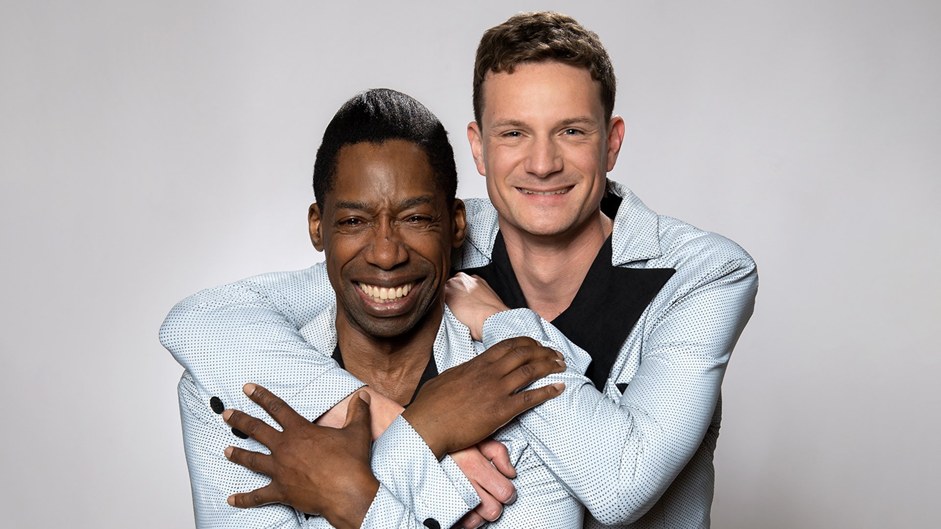 Das Künstlerpaar umarmt sich und lacht