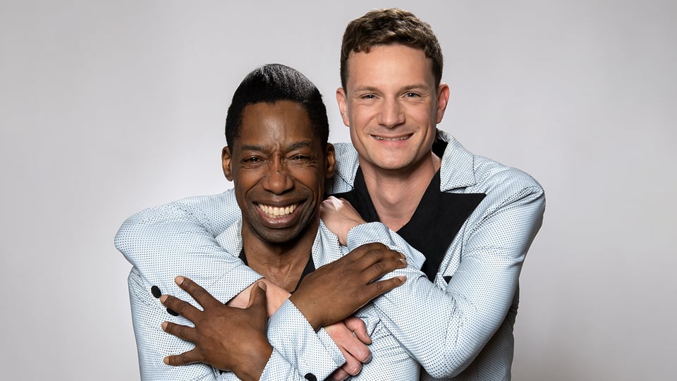 Das Künstlerpaar umarmt sich und lacht