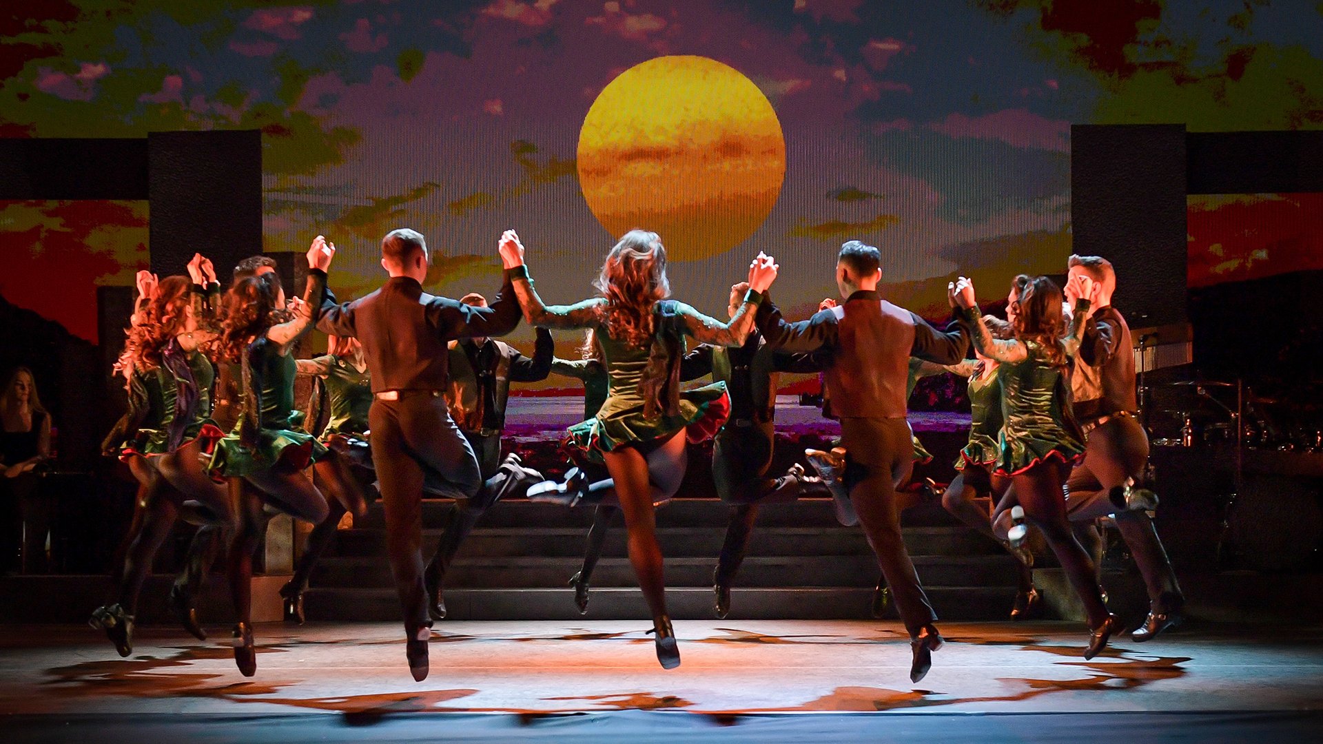 Das Ensemble tanzend auf der Bühne mit Mondschein im Hintergrund
