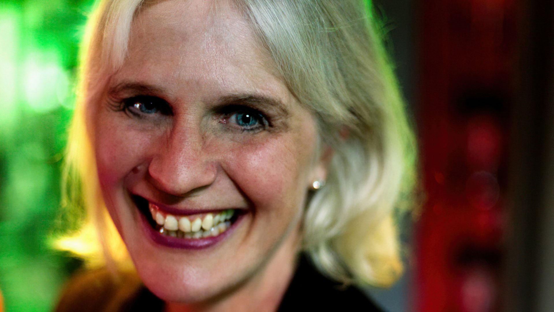 Foto für das Event von Susanne Wendel mit dem Gesicht der Künstlerin und im Hintergrund grünen und roten Lichtern