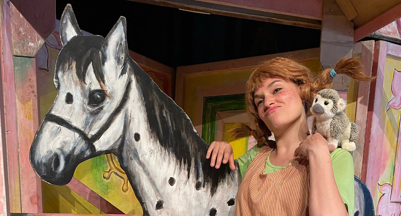 ein als „Pippi Langstrumpf“ verkleidetes Mädchen mit dem Affen und dem Papierpferd