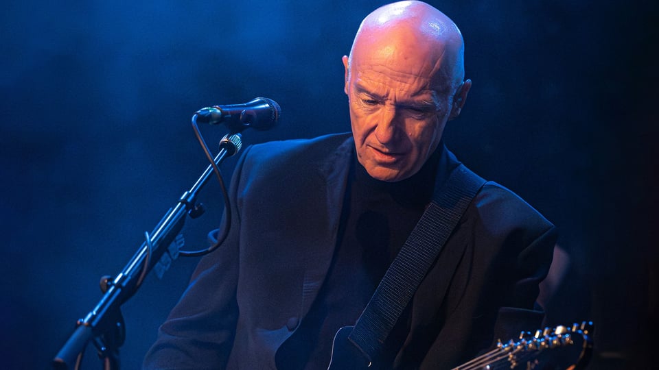 Der Künstler mit auf der Bühne mit Gitarre und Mikrofon