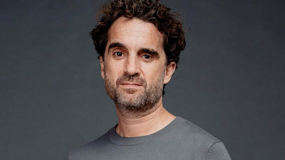 Ein Portrait von Oliver Wnuk in grauem Pullover und grauem Hintergrund
