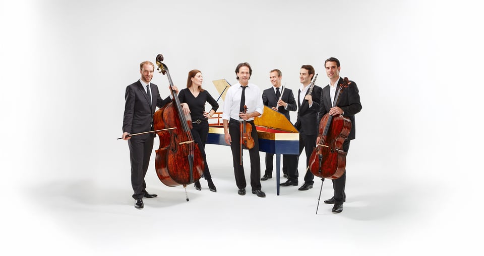 Sechs Musiker mit Instrumenten stehend vor weissem Hintergrund