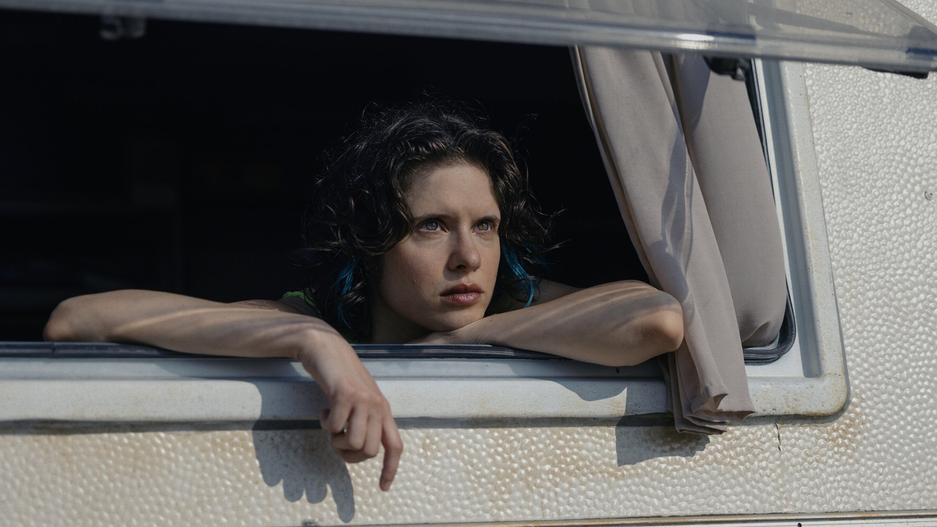 Ein Foto für das Event „Our Wildest Days“ bei der Griechischen Filmwoche München: Eine Frau schaut aus dem Fenster eines Wohnwagens.