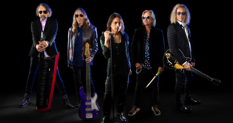 Foreigner vor einer schwarzen Wand