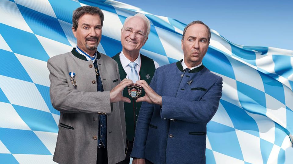 Foto für die Veranstaltung Wolfgang Krebs mit drei Männern und der bayerischen Flagge im Hintergrund.