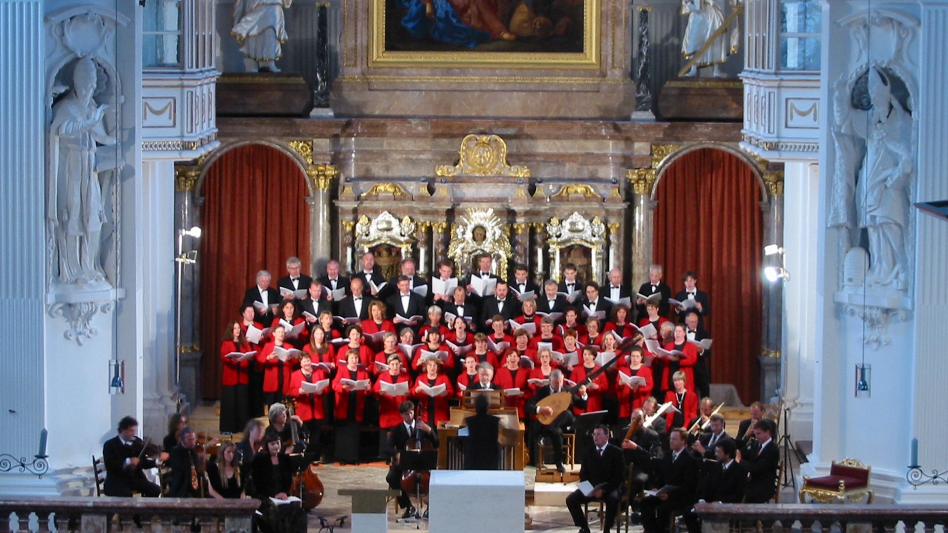 Foto für die Veranstaltung ‚St. Quirinus Konzerte Tegernsee‘ mit einem Chor, der in einer Kirche singt