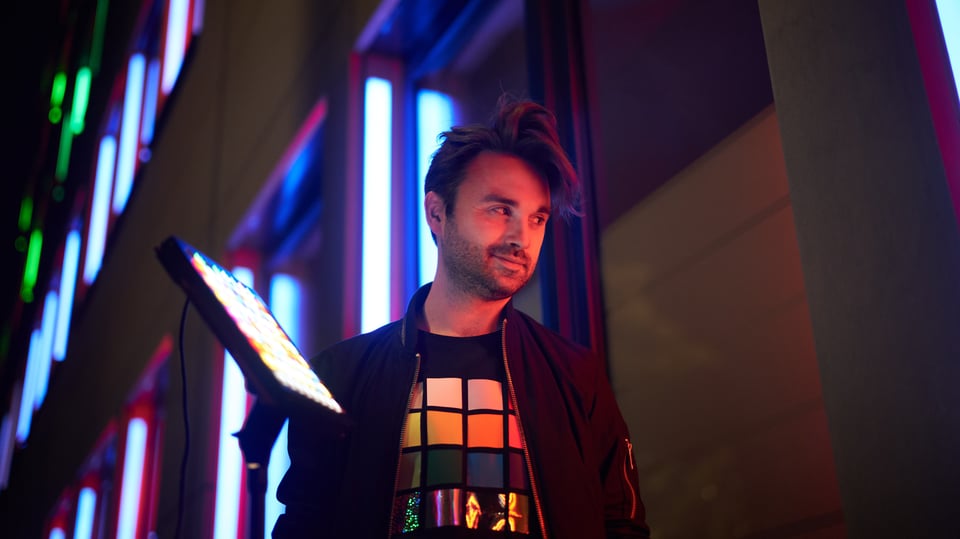 Foto des Künstlers, im Hintergrund Leuchtreklamen