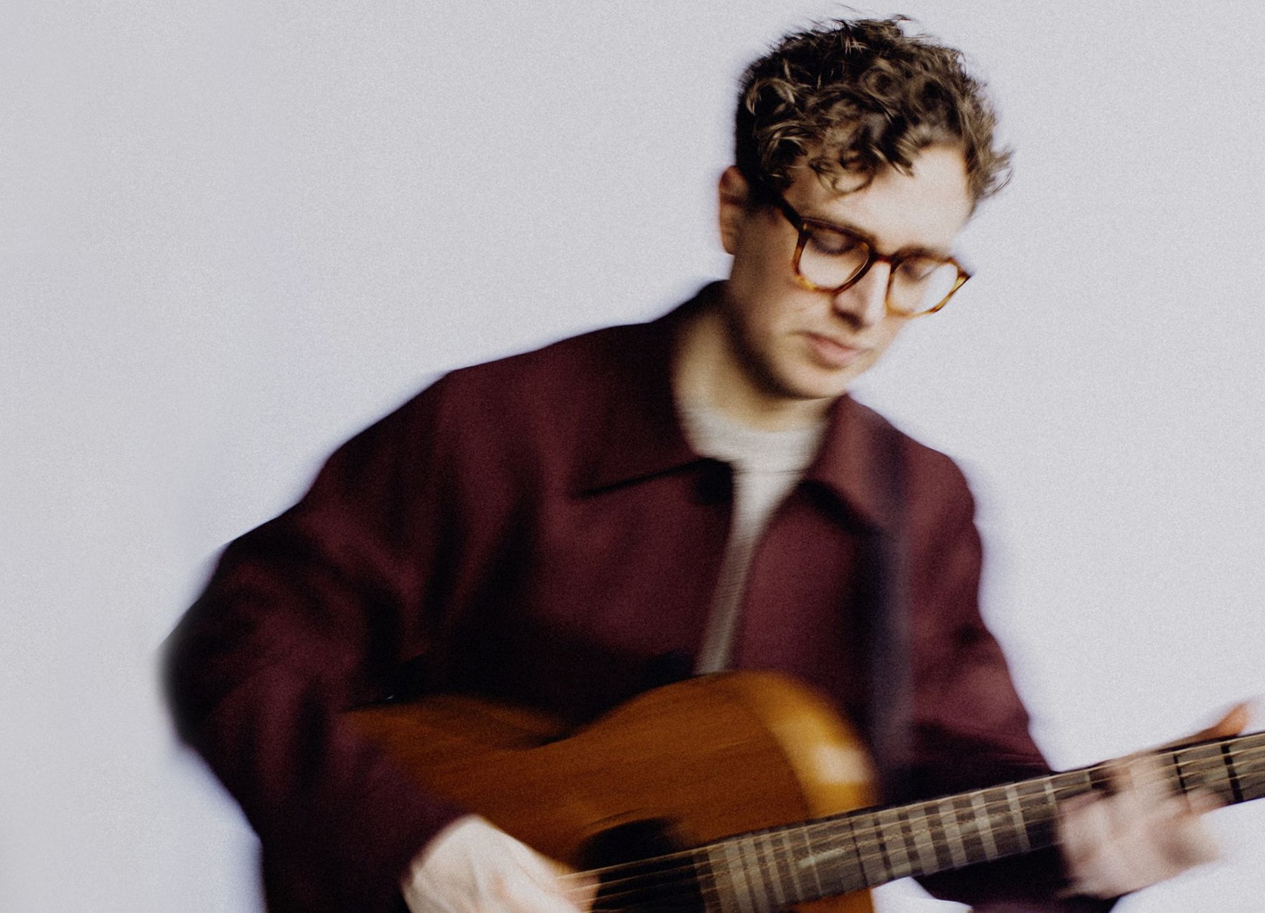 Phil Siemers spielt vor einem weißen Hintergrund Gitarre