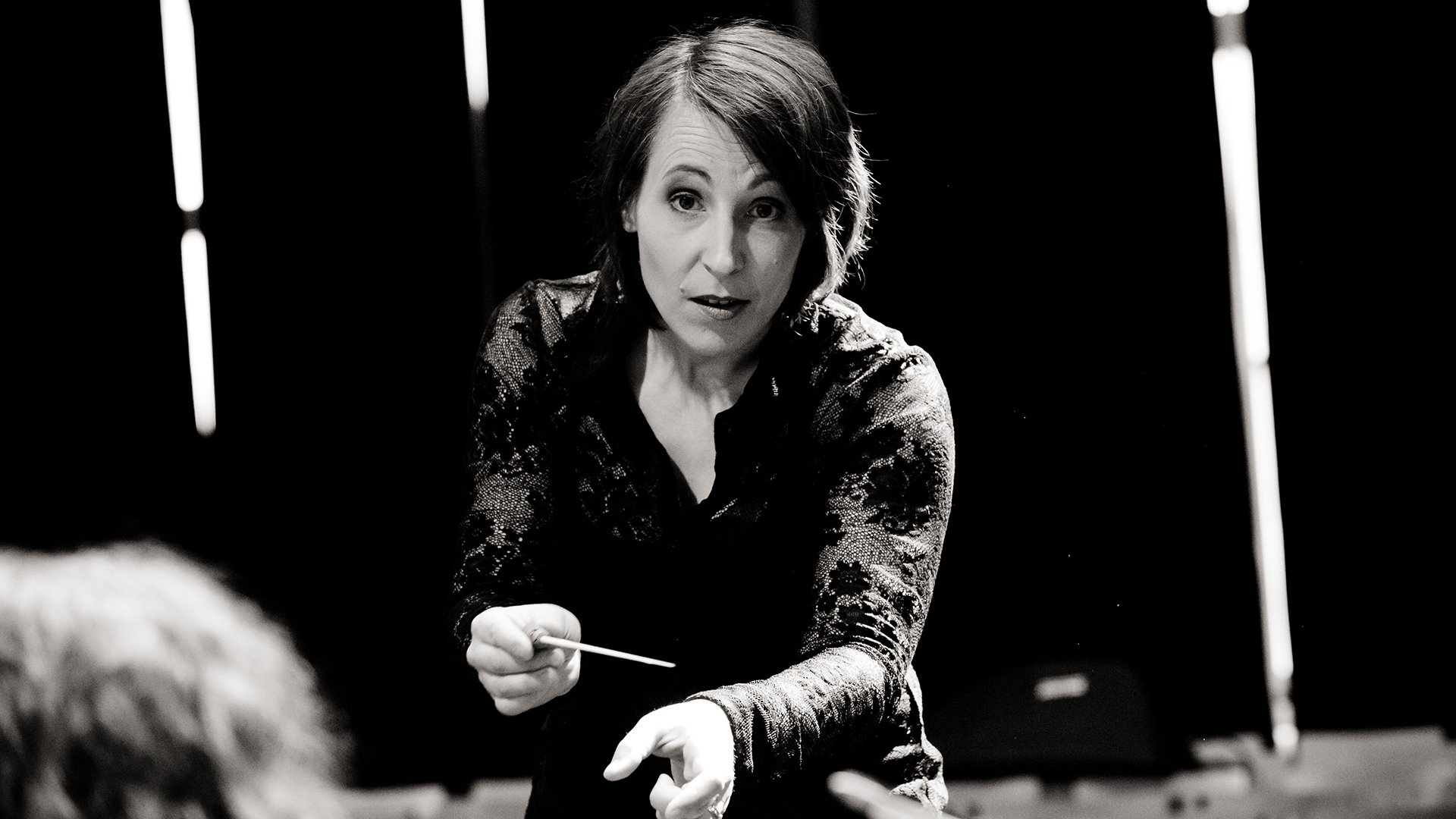 Schwarz weiss Bild der Dirigentin auf der Bühne
