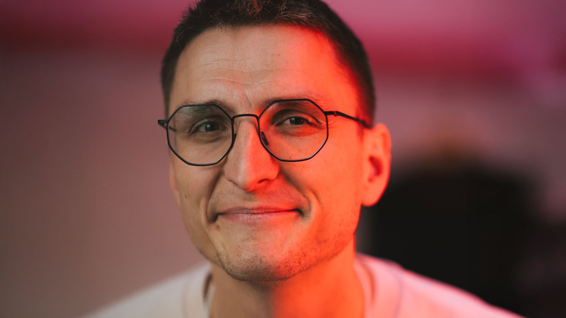 Foto für die Veranstaltung von Johannes Steuding mit dem Künstler vor einem Hintergrund aus rot‑schwarz verlaufenden Farben