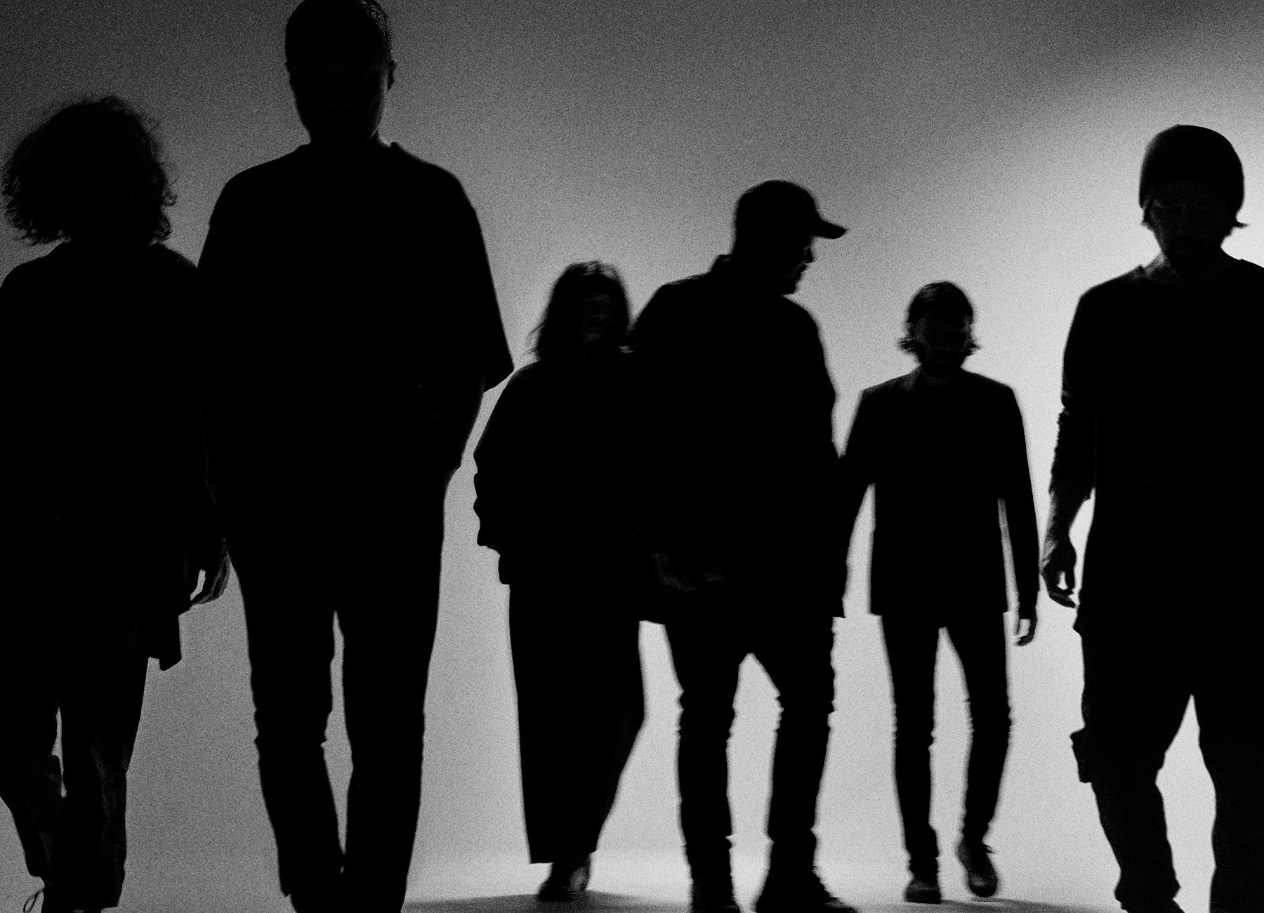 Schwarz-weiss Bild von Schatten von sechs Personen 