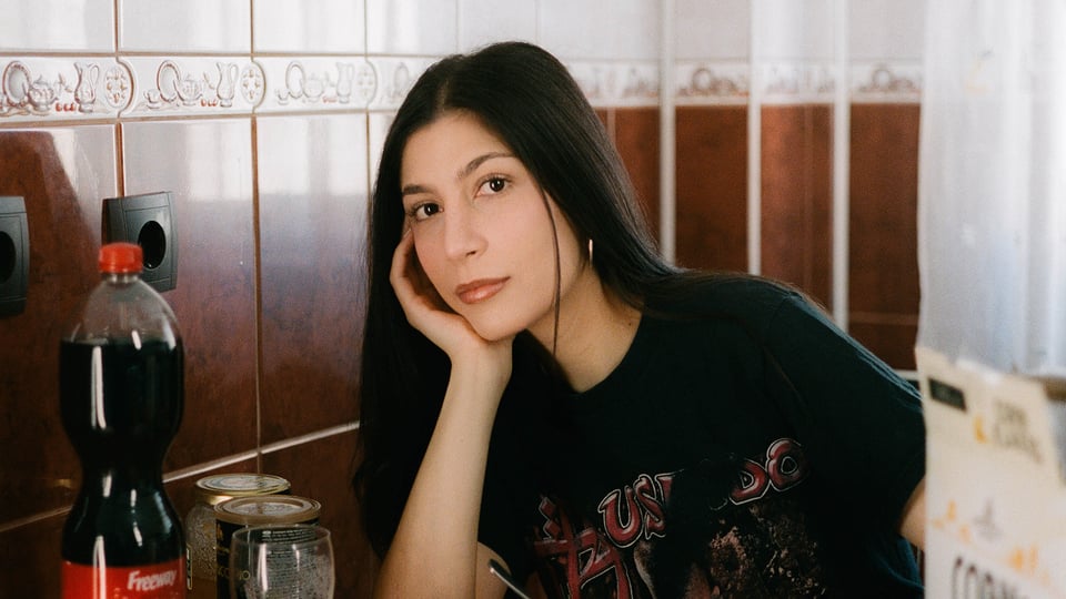 Porträt von Miriam Davoudvandi in einer Küche sitzend