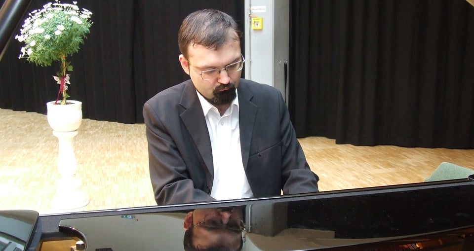 Foto des Künstlers am Klavier sitzend und spielend