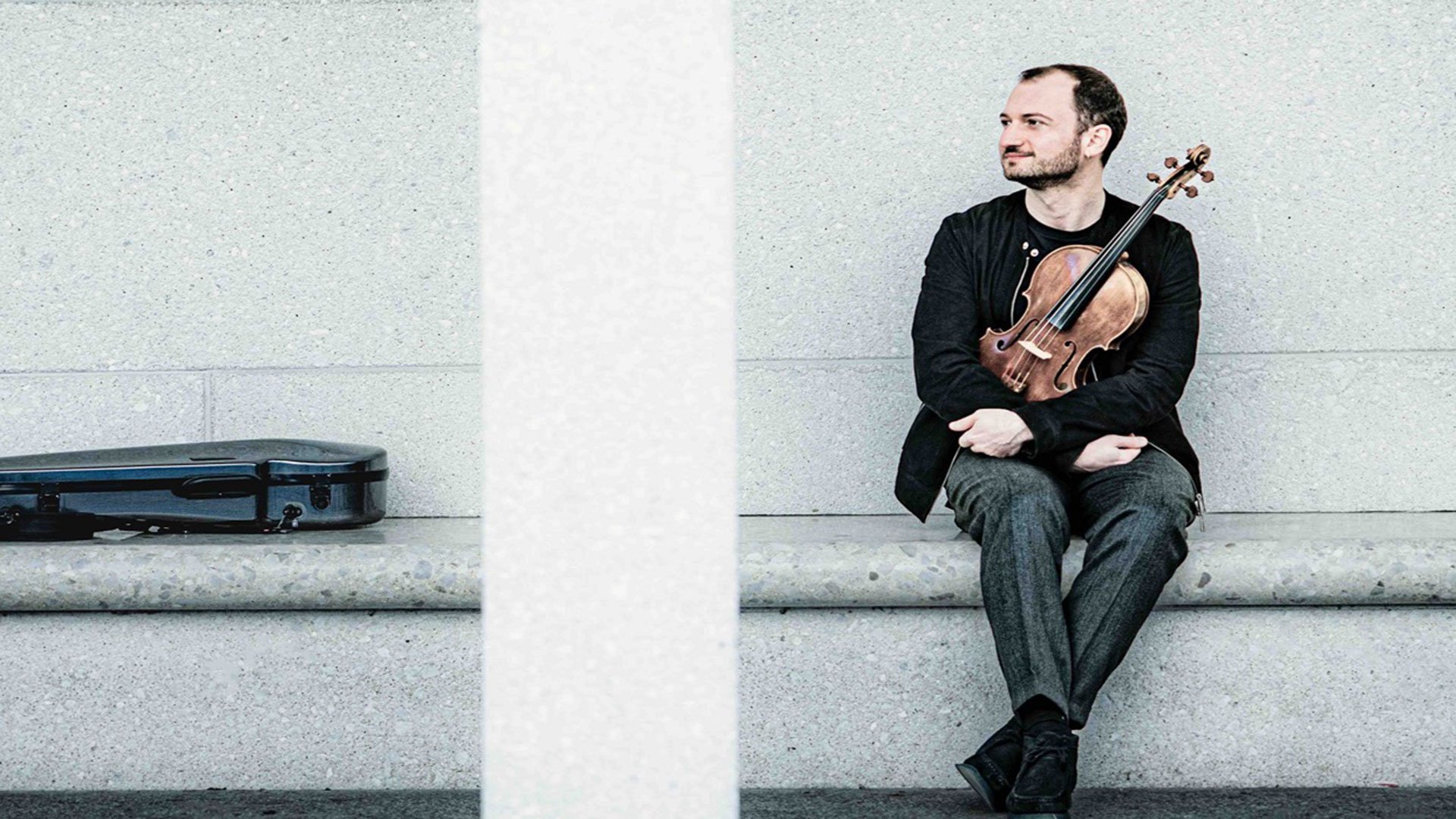 Foto für das Event InselKonzerte I mit dem Künstler German Tcakulov, sitzend auf einer Bank mit seinem Instrument.