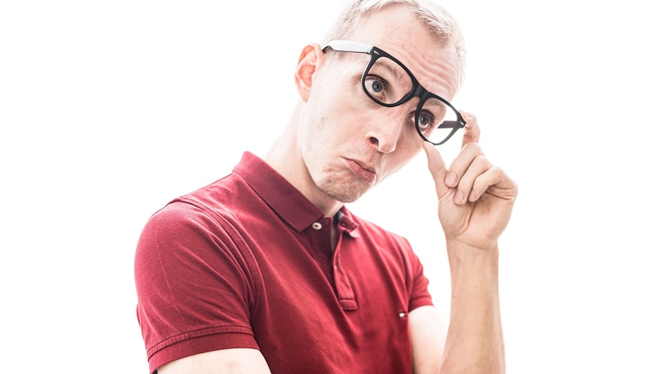 Der Künstler mit Brille und rotem Shirt vor weißem Hintergrund